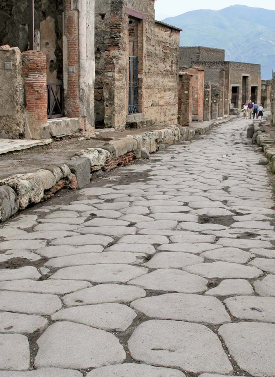 A photograph of the paved streets of Pompeii The stone pavers are irregularly shaped but are fitted together to minimize the grout between them , creating an irregular geometric pattern.