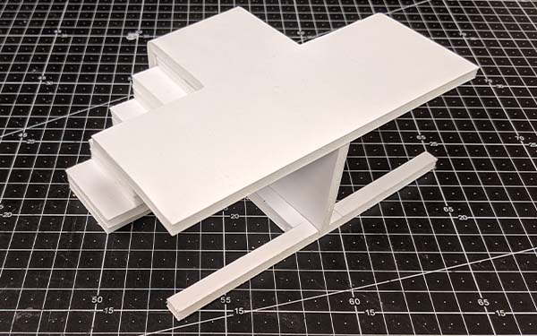 Side 2 of foam core table model C, the front of the “T” shaped table top is open and the legs form a “T” with the center support running its width.