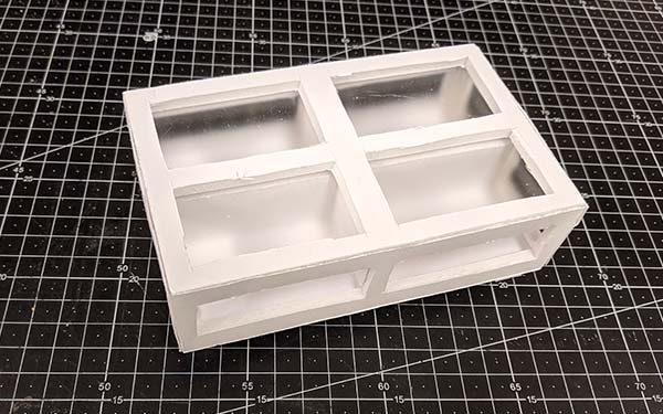 Side 1 of foam core table model E, a fully framed rectangle with a cross on the top creating 4 sections, and the frontmost side (due to the crossed material visible from the top) is split into two rectangular sections.