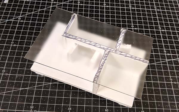 Foam core table model H is similar to table model G but with asymmetrical interior sections holding up the table top. There are four straight supports that run perpendicular to the table edges. And “doors” are open between the created sections below the glass table top