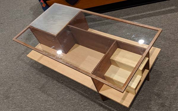 The full-scale wooden model of the final concept table with the glass top. The top-left corner is fogged above the square section with the pullout door, and the rightmost “room” is the smallest rectangular room with the mini staircase. 