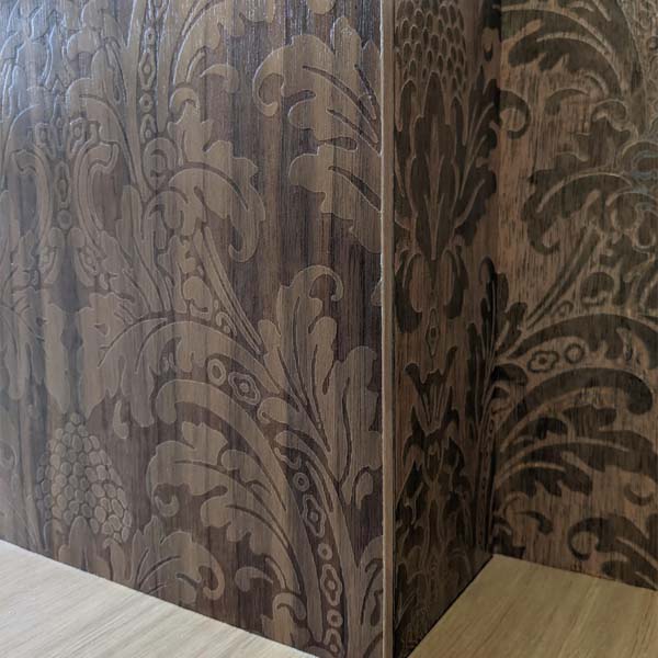 A closeup image of the L-shaped (or living room) wall. The Blake Damask pattern that was rastored onto the walnut reflects light differently depending on the angle: appearing darker or lighter than the surrounding oak due to the light’s reflection. 